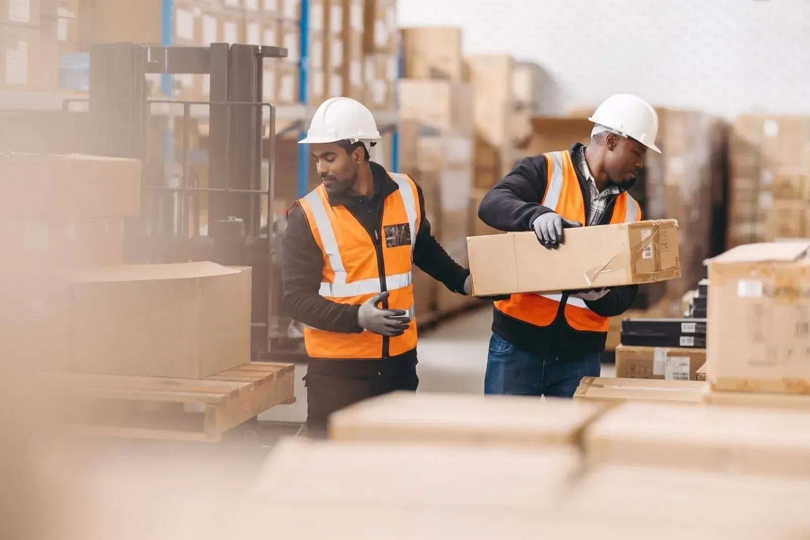 Two warehouse workers handling boxes